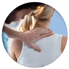 Close-up of hands placed on the upper back and shoulder area of a person wearing a white sleeveless top.